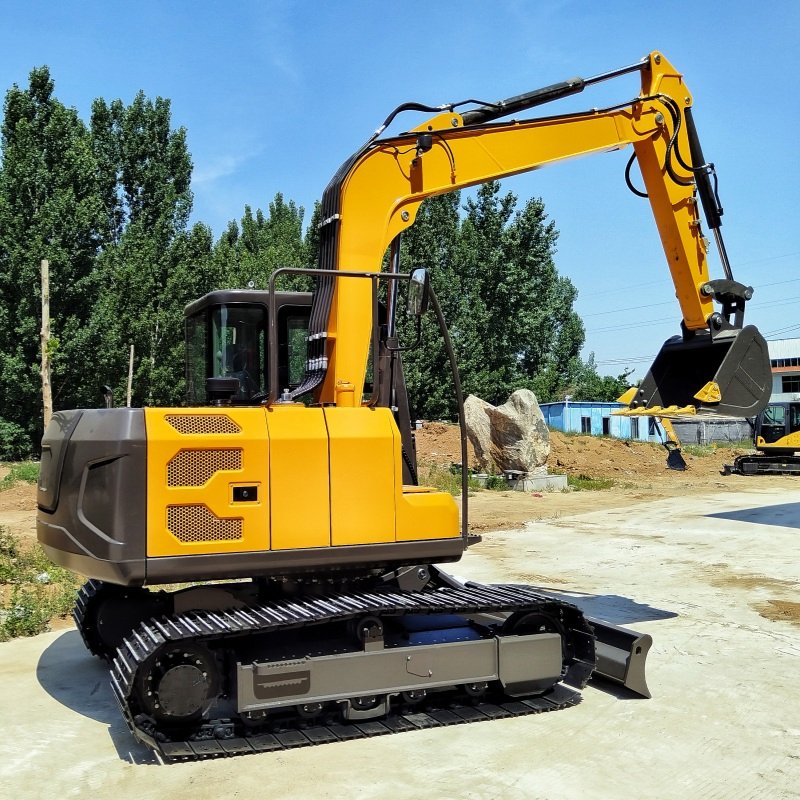 Rear view of mid-class compact excavator with steel tracks and dozer blade