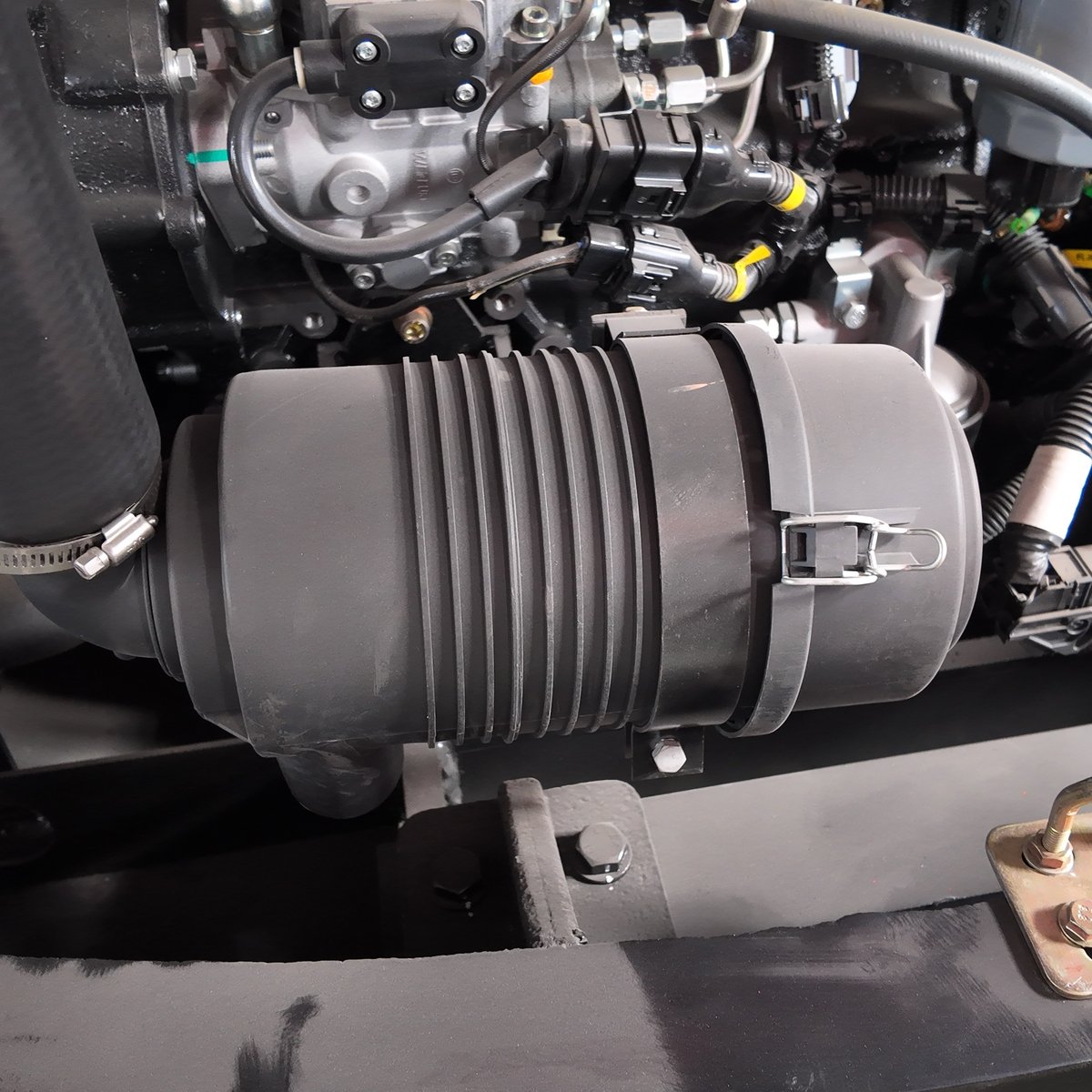Excavator engine bay showing hydraulic hose routing, clamping and component layout