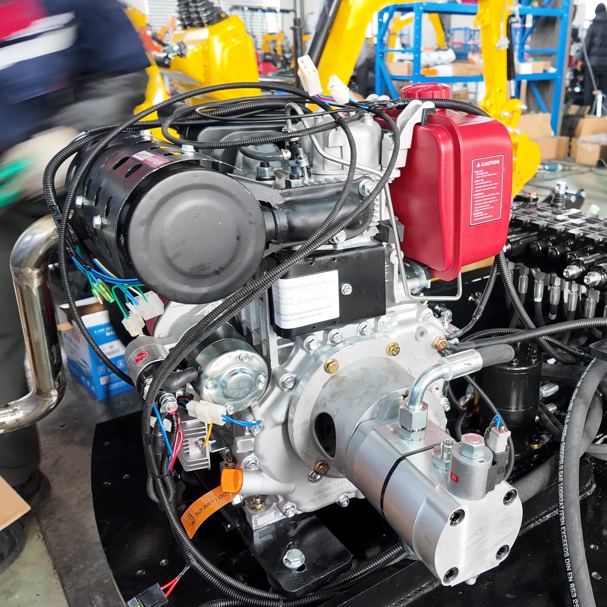Engine, hydraulic pump and multi-way control valve assembly on a mini excavator during factory assembly
