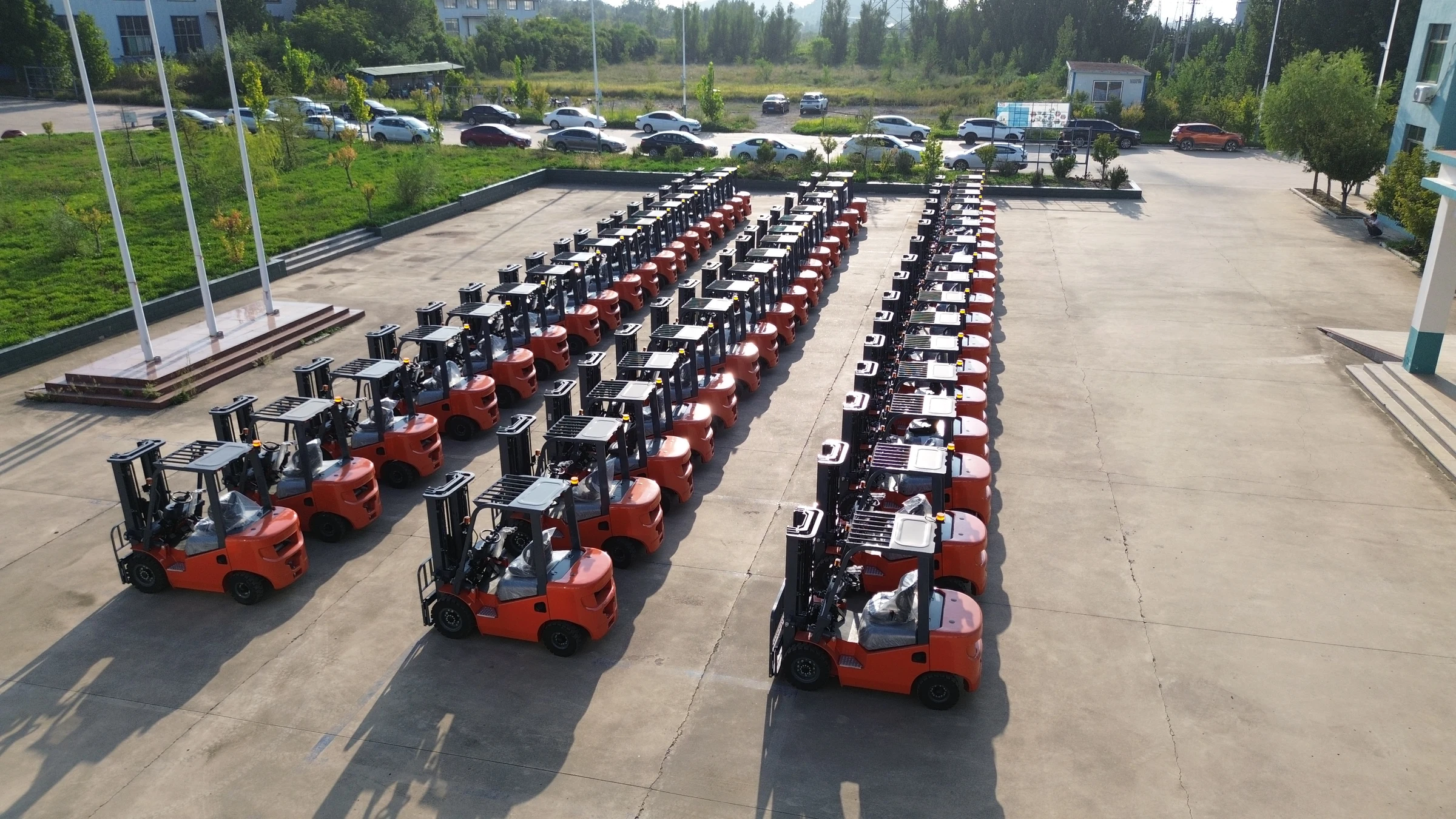 Three rows of red LeiTeng forklifts parked in a yard