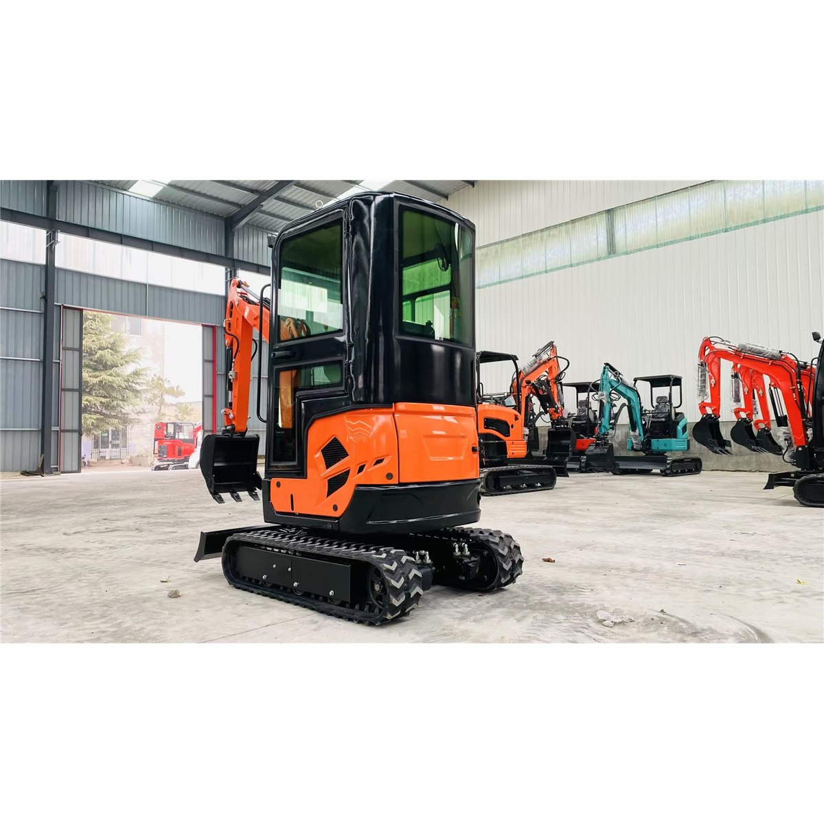 Rear view of an orange HL18 excavator with enclosed cab and rubber tracks in a workshop
